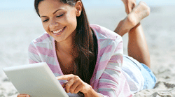 Lady-on-beach-reading-tablet-250x139